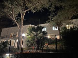 a building with a fence and trees at night at VILLA TARA in Quercianella