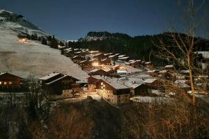 eine kleine Stadt im Schnee in der Nacht in der Unterkunft Le Petit Chalet du Chinaillon in Le Grand-Bornand