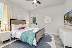 Un dormitorio blanco con una cama grande y una ventana en Disco Den-5 min to UofA-Bikes available, en Fayetteville