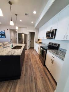 a large kitchen with white cabinets and wooden floors at Monroe Mountain Suite - Castle Rock Condos in Richfield