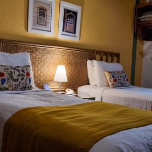 a hotel room with two beds and a lamp at Pouso 22 in Pirenópolis