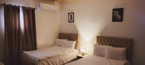 - une petite chambre avec 2 lits et une fenêtre dans l'établissement Carpet Alaadein Pyramids view, au Caire