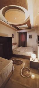 - une chambre avec deux lits et un plafond circulaire dans l'établissement Carpet Alaadein Pyramids view, au Caire