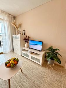 a living room with a television and a bowl of fruit at Apartamento completo junto a la playa in Salou