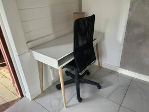 een wit bureau met een zwarte stoel in een kamer bij L'EdenKrys 2 avec son jacuzzi in La Trinité