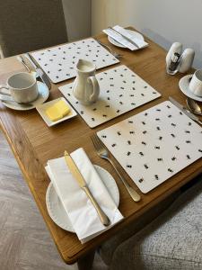 a wooden table with plates and utensils on it at Bramwood Guest House in Pickering