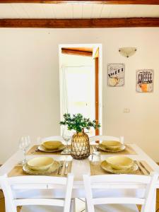 a dining room table with plates and a vase on it at La Casa di Gió in Centro in Olbia