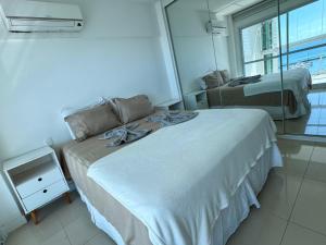 een slaapkamer met twee bedden en een groot raam bij Ap com vista mar - Cloc Marina! in Salvador +46 foto's