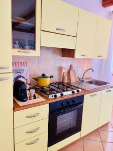 a kitchen with white cabinets and a stove top oven at La Casa di Gió in Centro in Olbia +28 photos