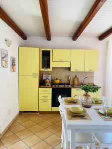 a kitchen with yellow cabinets and a table at La Casa di Gió in Centro in Olbia