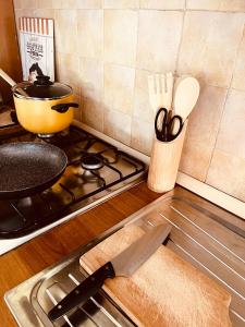 un bancone della cucina con un coltello e una padella su un fornello di La Casa di Gió in Centro a Olbia