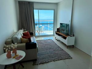 een woonkamer met een bank, een tafel en een tv bij Ap com vista mar - Cloc Marina! in Salvador