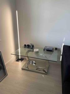a glass table sitting on a wooden floor at Modern 2 Bedroom House, Edinburgh. in Millerhill