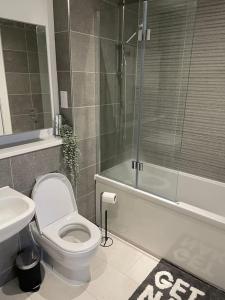 a bathroom with a toilet and a shower and a sink at Modern 2 Bedroom House, Edinburgh. in Millerhill