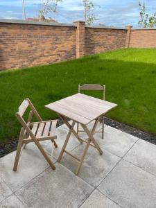 a picnic table and a chair sitting next to a lawn at Modern 2 Bedroom House, Edinburgh. in Millerhill