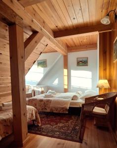 - une chambre avec 2 lits dans une pièce dotée de plafonds en bois dans l'établissement Gospodarstwo Gościnne Jesionówka, à Goworów