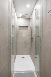 La salle de bains est pourvue d'une douche avec une porte en verre. dans l'établissement Luxury Family Home Heated Pool by LoveTenerife, à Los Cristianos