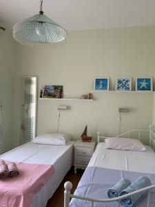 a bedroom with two beds and a chandelier at Villa Palma in Skala Rachoniou