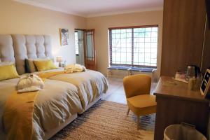1 dormitorio con 1 cama grande, escritorio y silla en Sandy Creek Safaris, en Kransberg
