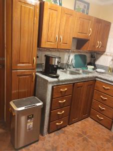 a kitchen with wooden cabinets and a trash can at Casa Abuelito's Andean Haven in Huaraz