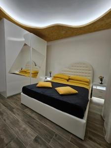 1 dormitorio con 1 cama grande con almohadas amarillas en La suite (Sole), en Lido di Pomposa