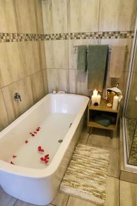 y baño con bañera con flores. en Sandy Creek Safaris en Kransberg