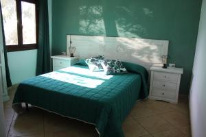 una camera verde con un letto e due comodini di GardenRocks a Fluminimaggiore