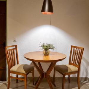皮雷諾波利斯的住宿－Pouso 22，一张桌子,上面有两把椅子和花瓶