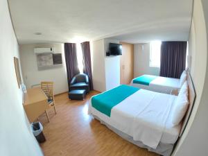 Habitación de hotel con cama y silla en Kasa Hotel & Suites, en Irapuato