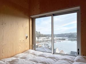 a bedroom with a large window overlooking a marina at Beautiful wood house and view in Audierne