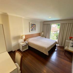 a hotel room with a bed and a window at Pousada Magister in Petrópolis