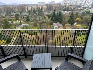 two chairs and a table on a balcony with a view at APARTAMENT WRAŻEŃ Kraków in Krakow