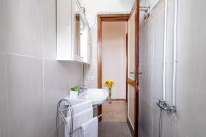 ein weißes Badezimmer mit einem Waschbecken und einem Spiegel in der Unterkunft The Sunrise Attico Panoramico in Porto Cesareo
