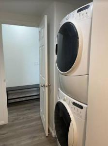 eine Waschmaschine, die an einer Wand in einem Zimmer hängt in der Unterkunft Walk 2mins to Shopping & Bussing,1-Bed Room Suite in Fort McMurray