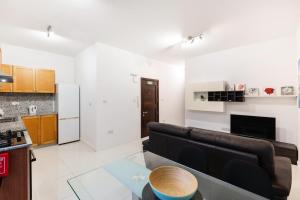 a living room with a couch and a kitchen at A Bright & Lovely 2 Bedroom Apartment 1 minute walk from promenade apartment 3 in Il-Gżira