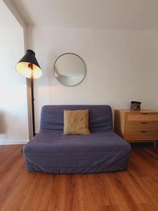 - un canapé bleu dans une pièce avec une lampe et un miroir dans l'établissement Studio *Centre-ville* Terrasse 20 m² ensoleillée, à La Grande Motte