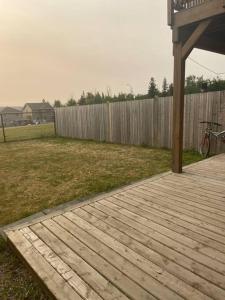 a wooden walkway in a yard next to a fence at Walk 2mins to Shopping & Bussing,1-Bed Room Suite in Fort McMurray