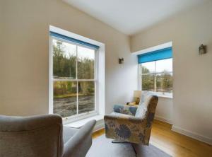 a living room with two chairs and two windows at Grade II listed house with river and castle views - Barnard Castle in Barnard Castle