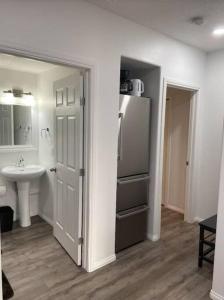 a kitchen with a sink and a refrigerator at Walk 2mins to Shopping & Bussing,1-Bed Room Suite in Fort McMurray