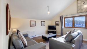 a living room with two couches and a tv at Lake District Apartment At Windermere Marina Village in Bowness-on-Windermere