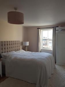 a bedroom with a white bed and a window at Beautiful house on stunning Richmond Hill in Richmond