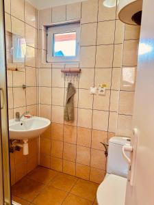 La salle de bains est pourvue d'un lavabo, de toilettes et d'une fenêtre. dans l'établissement Bamboo Rooms, à Štúrovo