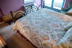 Una cama con una manta en una habitación en Elk River Hotel & Cafe en Sutton