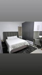 sypialnia z łóżkiem, biurkiem i krzesłem w obiekcie Mountain Drive Apartments w mieście Mbabane