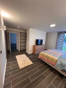 um quarto com uma cama e piso em azulejo em Maison Familiale em Vitry-sur-Seine