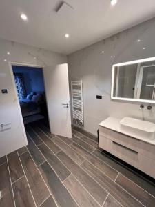 uma casa de banho com 2 lavatórios e um espelho grande em Maison Familiale em Vitry-sur-Seine