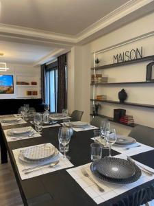 uma sala de jantar com uma mesa longa com pratos e copos em Maison Familiale em Vitry-sur-Seine