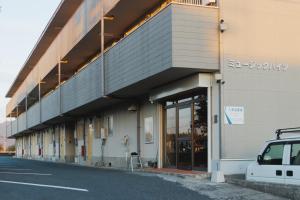 a building with a parking lot with a car parked outside at Quilotoa Mifune Guesthouse in Mifune