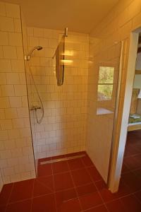 y baño con ducha de azulejos blancos. en Malběnka - chata na skále pod hradem Kokořín en Kokořín