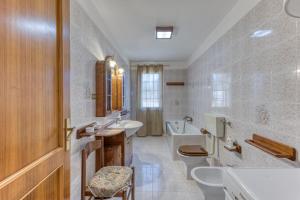 łazienka z 2 toaletami, umywalką i wanną w obiekcie Casa Puzzedde w mieście Castrignano del Capo